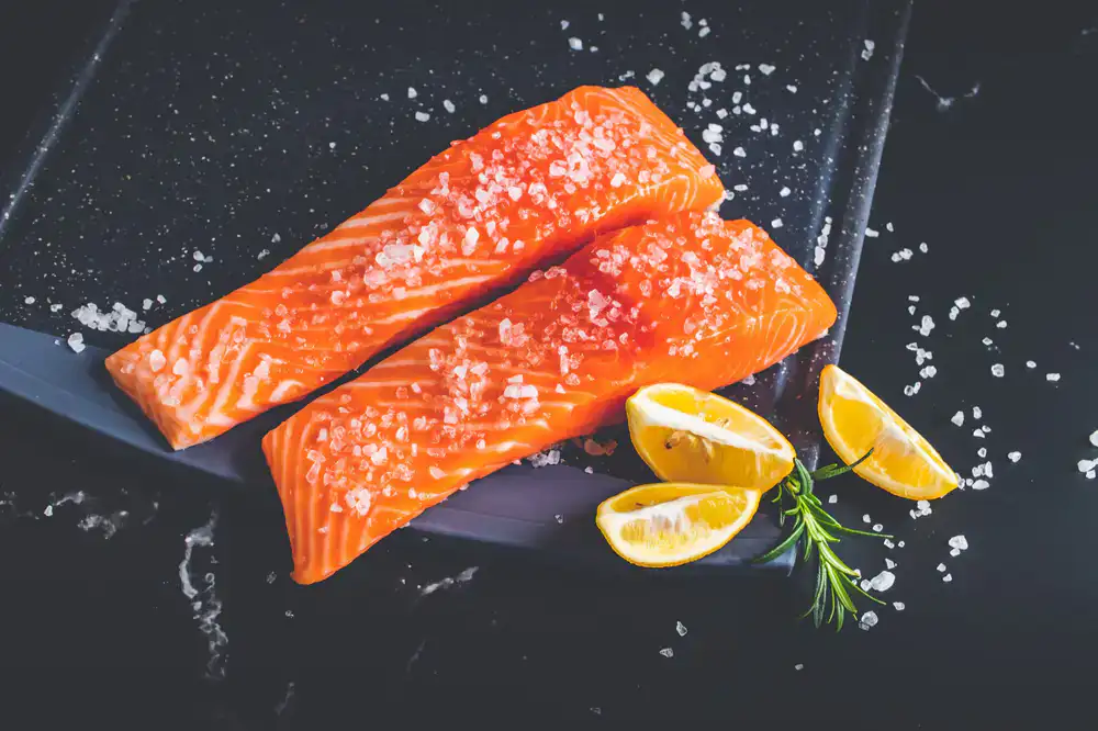 Fresh seafood being prepared with herbs and citrus on a kitchen counter