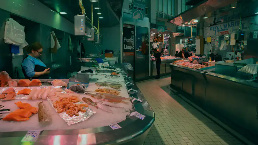 Fishmonger preparing fresh fish fillets at the counter